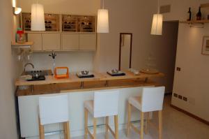 une cuisine avec un comptoir et des tabourets blancs dans l'établissement Hotel Residence Vatican Suites, à Rome