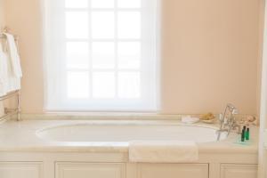 a white bath tub in a bathroom with a window at Château du Tertre in Arsac