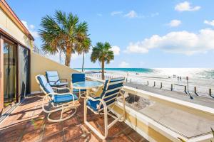 a balcony with chairs and a table and the beach at Fanta-Sea 47 By Beachside Management in Siesta Key