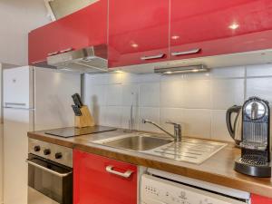 a kitchen with red cabinets and a sink at Studio cabine à Megève pour 4 pers, avec balcon, animaux admis, proche télécabine - FR-1-453-323 in Megève
