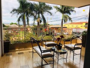 a balcony with three chairs and a table with a view at Cerrado Gran Hotel in Rio Verde