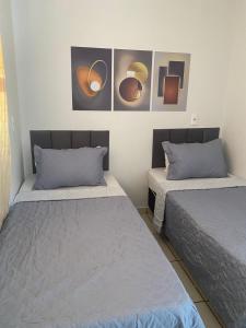 two beds in a room with paintings on the wall at Cerrado Gran Hotel in Rio Verde