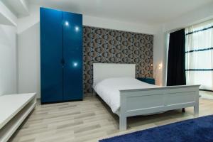 a bedroom with a bed and a blue cabinet at Aparthotel Jolie in Galaţi