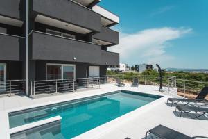 een zwembad voor een gebouw bij Mila Deluxe in Novalja