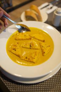 a white plate with a bowl of yellow sauce at ONOMO Hotel Tanger Med in Tangier