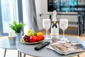 Una mesa con una botella de champán y un bol de fruta. en Stylish 2 Bedroom Apartment - City Centre - Large Balcony - Secure Parking 1001M, en Birmingham