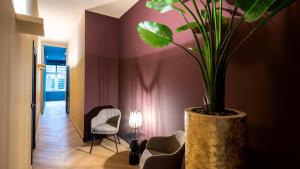 a plant in a pot in a hallway with a lamp at Breda City Apartments in Breda