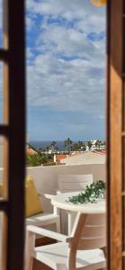 einen Balkon mit Blick auf einen Tisch und Stühle in der Unterkunft Apartament z widokiem na Ocean in Costa de Adeje