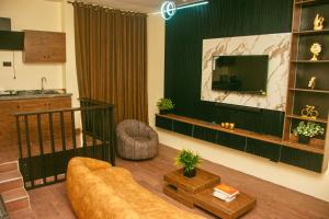 a living room with a couch and a tv at Hotel Fountain Blu in Abeokuta