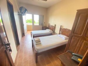 a room with two beds and a window at Abaeté Palace Hotel in Abaeté