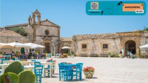 a courtyard with blue chairs and a building at Noto Barocca - HolidayHome in Noto
