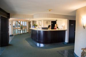 two women standing at a bar in a hotel lobby at Admiral Inn Hamilton in Hamilton