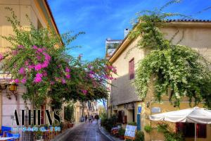 eine schmale Straße mit Blumen, die von Gebäuden hängt in der Unterkunft Athenian Exclusive residence 4&2 ppl in Athen