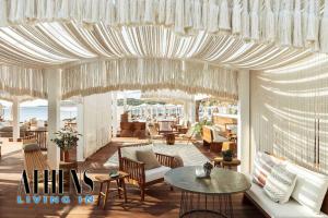 ein Wohnzimmer mit Stühlen, Tischen und einer Decke in der Unterkunft Athenian Exclusive residence 4&2 ppl in Athen