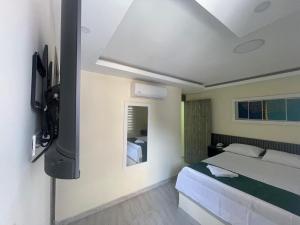 基布多Hotel Magistral Suiter的卧室里有一张床和一台电视机