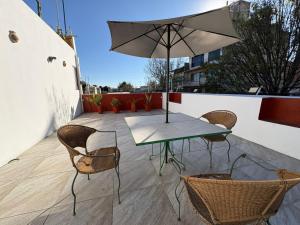 a patio with a table and chairs and an umbrella at Casa Oaxaca in Oaxaca City