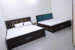 two beds sitting next to each other in a room at Bhawna Guest House in Vrindāvan
