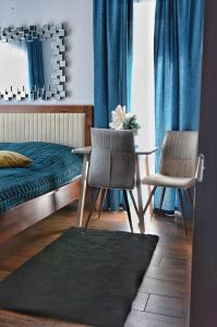 a bedroom with a bed and two chairs and a table at Villa Corleone in Kąty Wrocławskie
