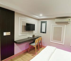 a room with a desk with a tv and a bed at Thanh Binh Premium Hotel in Ho Chi Minh City