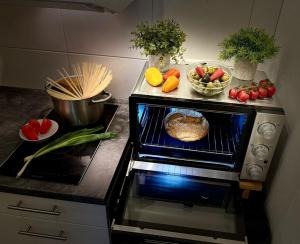 a kitchen with an oven with a food cooking in it at Bodensee Strandläufer Quartier in Daisendorf