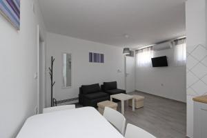 a white room with a couch and a living room at House Lavanda - Kricin, underground level apartment in Baška
