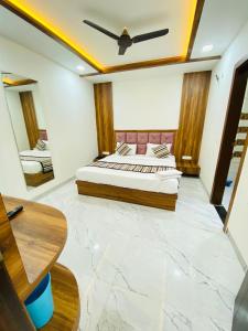 a bedroom with a king sized bed and a mirror at Taj Comfort Inn in Agra