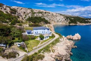 an aerial view of a house on the shore of a body of water at House Lavanda - Kricin, underground level apartment in Baška