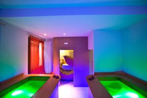 a room with two jacuzzi tubs with purple and green lighting at Hotel Villa Ricci & Benessere in Chianciano Terme