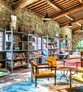 a room with chairs and tables and bookshelves at Il Giardino e la Dimora in Bomarzo