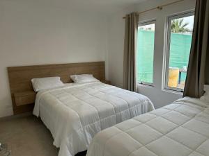 Ένα ή περισσότερα κρεβάτια σε δωμάτιο στο Casa Paraquitas "Casa Frente al mar de Paracas"
