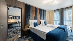 Un pat sau paturi într-o cameră la Wellton Riverside SPA Hotel