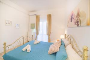 a bedroom with a blue bed with towels on it at Karia Holiday Home in Lefkimmi