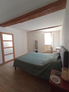 une chambre avec un lit vert et une fenêtre dans l'établissement Gite de Paola, à Boulbon