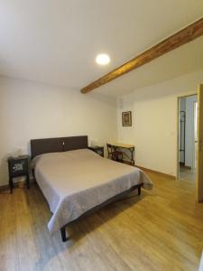 une chambre avec un lit et un parquet dans l'établissement Gite de Paola, à Boulbon