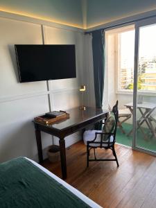 a bedroom with a desk and a tv on the wall at Rambla Apart in Montevideo