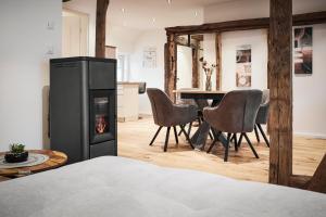 a living room with a fireplace and a table with chairs at Finkenhof in Lennestadt