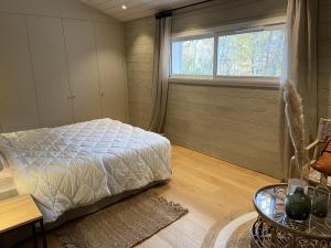 a bedroom with a bed and a window at Grand Chalet de Pitrot in Lacanau
