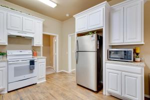 a white kitchen with a refrigerator and a microwave at Historic Home Half-Mile to Downtown Guthrie! in Guthrie