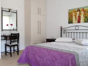 a bedroom with a bed and a desk and a mirror at Green View Apartments in Agios Nikitas