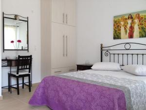 sypialnia z łóżkiem, biurkiem i lustrem w obiekcie Green View Apartments w mieście Agios Nikitas