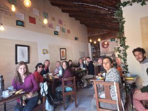 a group of people sitting at tables in a restaurant at Hostal Casa Grande in Villazón