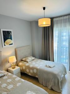 ein Schlafzimmer mit zwei Betten und einer Lampe in der Unterkunft Golden Horizon Costa del Sol, Duquesa residence in San Luis de Sabinillas