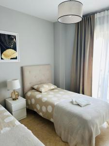 ein weißes Schlafzimmer mit 2 Betten und einer Lampe in der Unterkunft Golden Horizon Costa del Sol, Duquesa residence in San Luis de Sabinillas + 10 Fotos