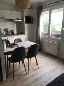 a kitchen with a table and chairs in a kitchen at Studio spacieux bord de mer in Camiers