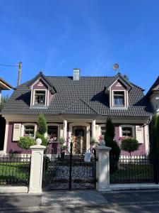 a pink house with a black iron fence at Landhaus am Schloss in Küps