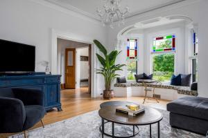 a living room with a blue couch and a table at 3bed 2bath heritage duplex - Prime Location in Collingwood