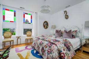 a bedroom with a bed and two chairs and windows at 3bed 2bath heritage duplex - Prime Location in Collingwood