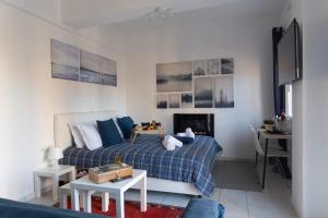 a living room with a bed and a table at Gk Suites-Constantin view , auto check-in 24h in Larisa