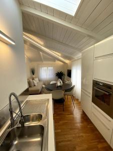 a kitchen with a sink and a table in a room at Grenier Blanc2 Elegante Mansarda 3 camere 5 ospiti in San Vicenzo di Galliera