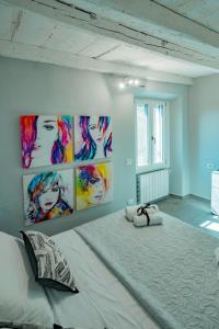 a bedroom with a large bed with paintings on the wall at La Perla sul Lago in Pescate